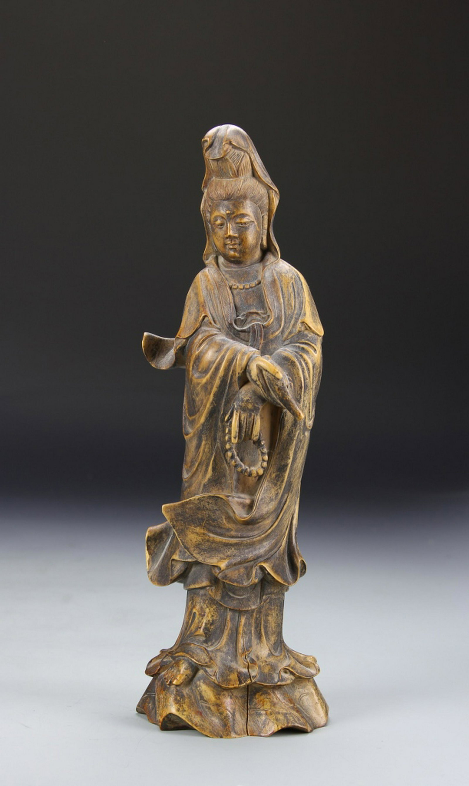 Chinese Antique Wood Guanyin Statue: China, antique wood Guanyin statue, wearing flowing robes and holding prayer beads, smooth finish highlighting natural grain and coloring. Height 10 1/4 in. Provenance: Private collection, Manhattan N