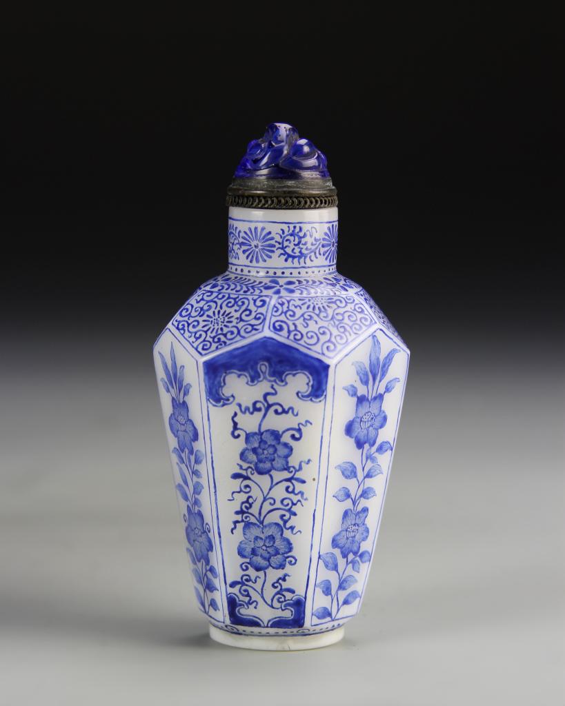 Chinese Peking Glass Snuff Bottle: China, ROC Period, Peking glass snuff bottle, triangle dome shaped stopper, body decorated with blue and white decoration of plant motifs and swirling design work. Height 3 1/4 in.