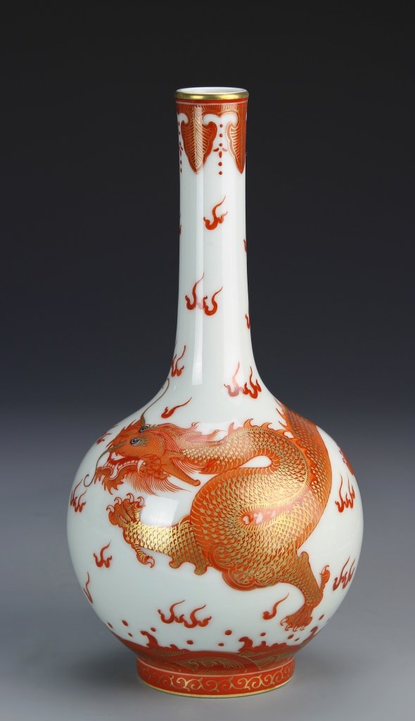 Chinese Copper Red and Gilt Vase: China, 19th C., copper red and gilt vase in a long neck form, painted in bright copper red and gold with an image of a five-clawed serpentine dragon amongst flames, Kangxi mark. Height 10 1/4 in.