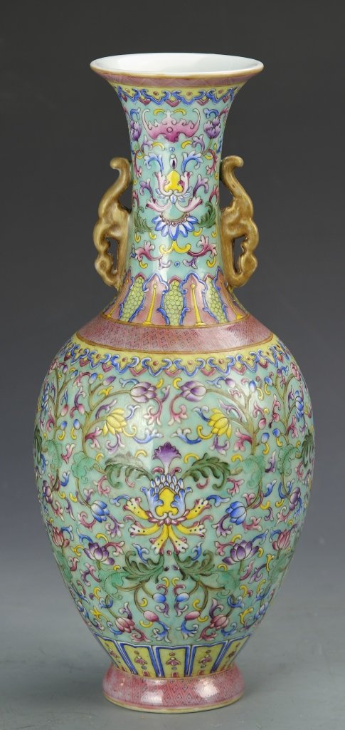 Chinese Famille Rose Guanyin Vase: China, Famille Rose vase, flared rim, long neck, bottle shape form with slightly flared base, decorative ears, reoccurring diamond design at the neck and base, with interlocking patterns throughout in