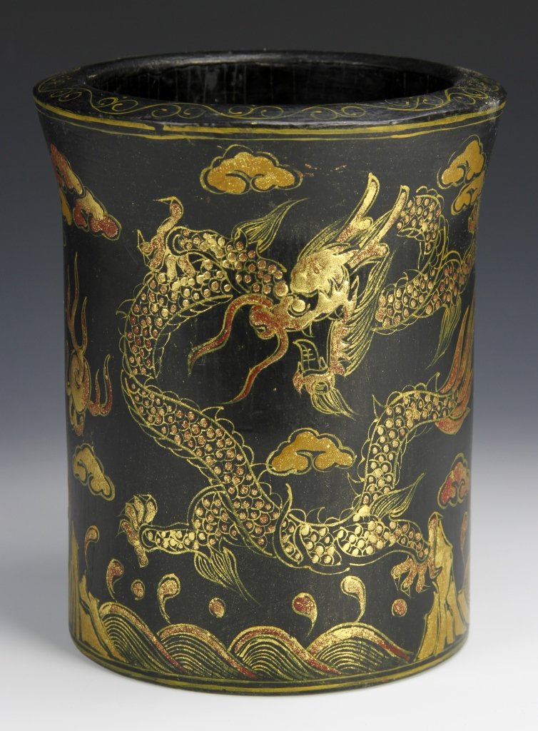 Chinese Lacquer Brush Pot: China, lacquer brush pot, cylindrical form with flared rim, gilt edging around rim and base, detailed pictures of dragons chasing the pearl through waves and clouds encircling the pot, mark on base. H