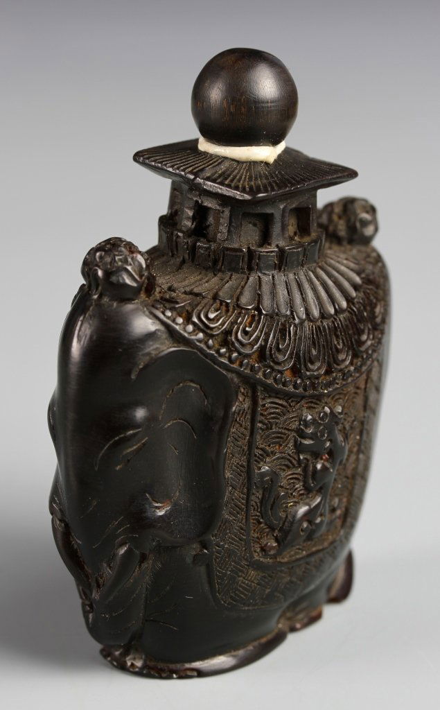 Chinese Horn Snuff Bottle: China, 19th C., carved horn snuff bottle in an irregular form, carved with chi dragons and auspicious symbols, with stopper. Height 3 in.