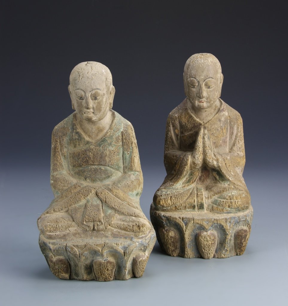 Chinese Wood Buddha: China, 18th C., two wood Buddha in seated positions with stylized faces and designs and natural grain wood. Height 11 in.