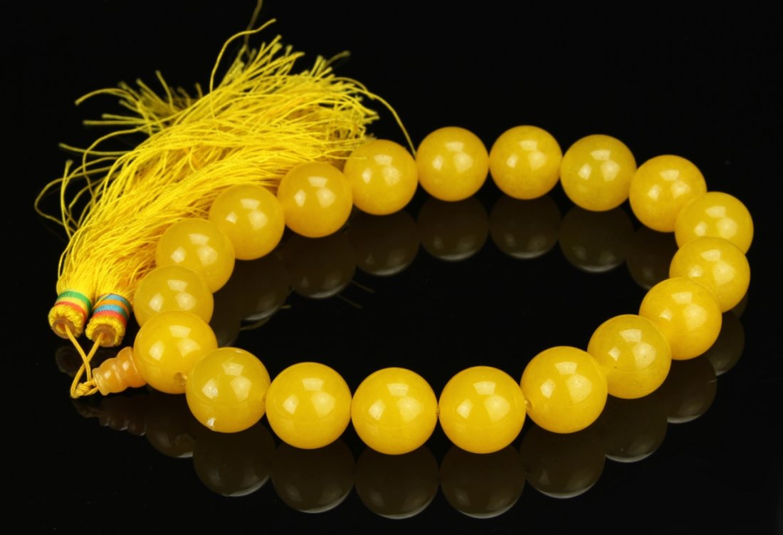 Chinese Yellow Jade Necklace: China, yellow jade necklace, comprised of 19 smoothly carved, circular beads, with matching yellow tassel. Length 14 in.