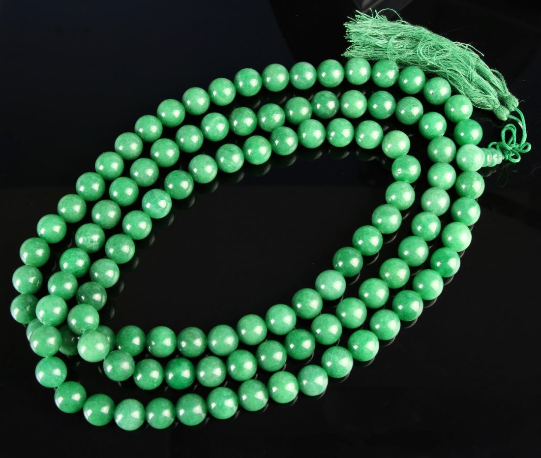 Chinese Jadeite Beaded Necklace: China, carved jadeite beaded necklace, three layers of stringed beads, all of similar size and rich green coloring, with matching green thread tassel. Length 48 in.