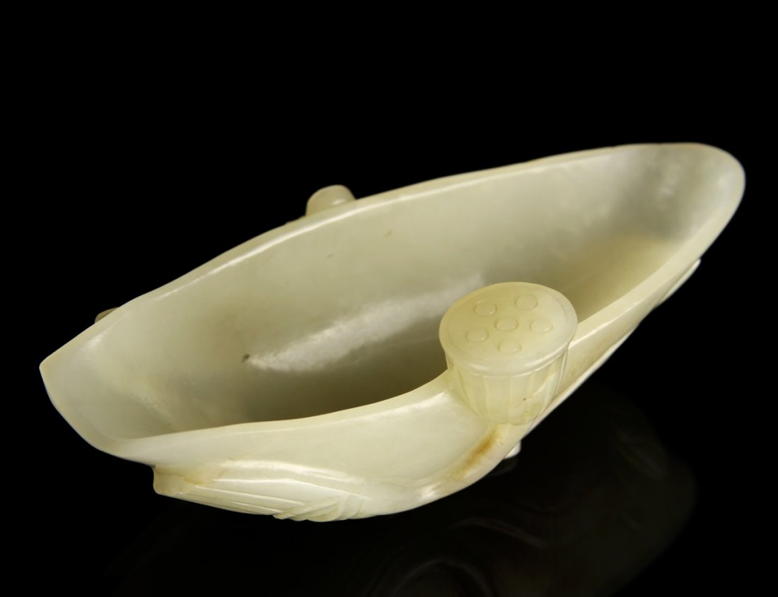 Chinese Carved Jade Brush Washer: China, 18th C., carved jade brush washer, in an organic form, with carved natural elements decorating the sides, including a lotus seed pod. Length 4 1/2 in., Width 1 3/4 in. Height 1 1/2 in. Provenan