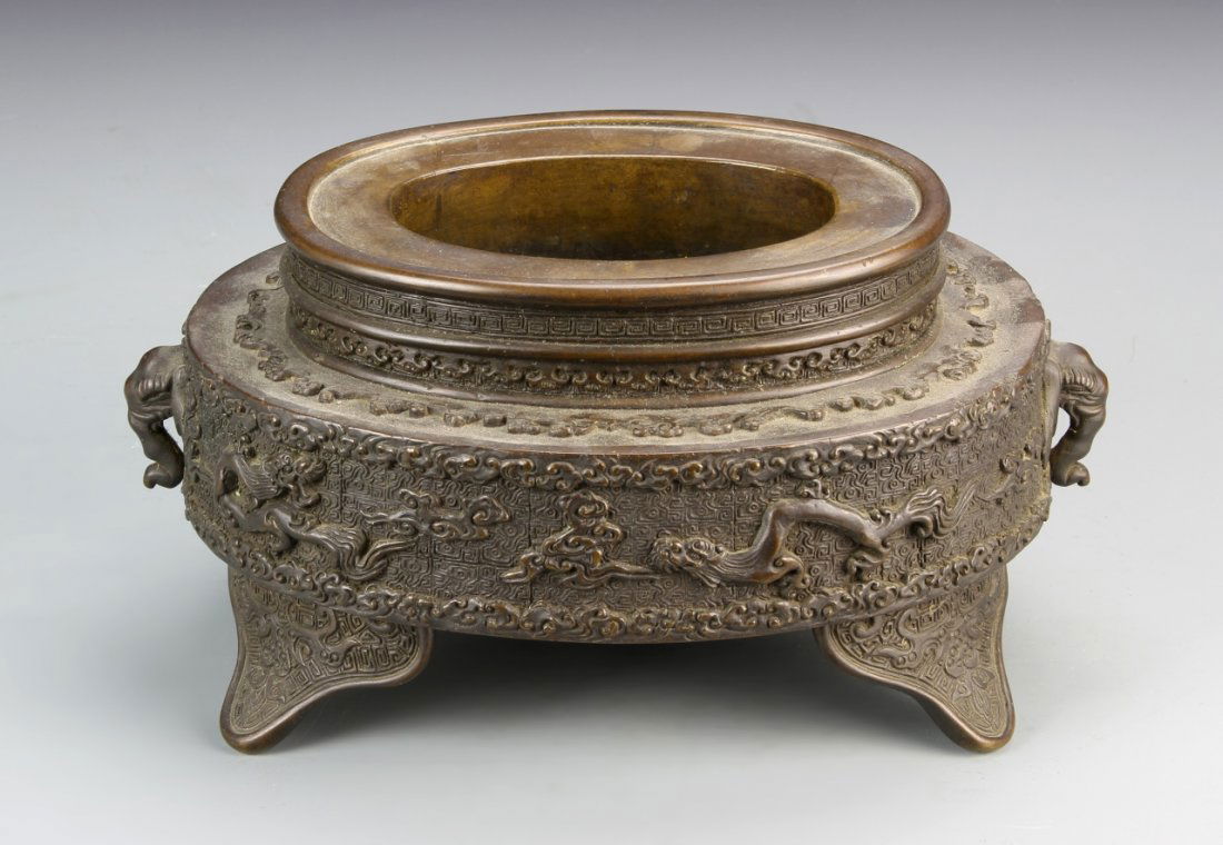 Japanese Censer: Japan, antique censer with patina and tapered rim on a tripod base, decorated with intricate raised detail. Height 5 1/2 in.