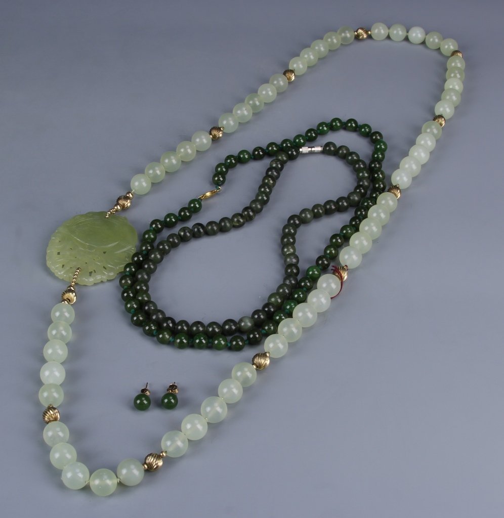Three Chinese Jade Necklaces and a Pair of Earpins: China, three jade necklaces, one with lighter green beads, smaller metal detail, and a larger accent bead, the other two with darker green beads and metal clasps, with a pair round green ear pins. Lar