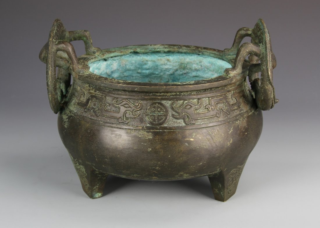 Chinese Bronze Censer: China, Bronze Censer, tripod censor, appropriate age wear, patina visible, bulbous body, with auspicious scrolling symbols on rim, with two stylized handles in the form of dragons, with Kang Xi mark. 