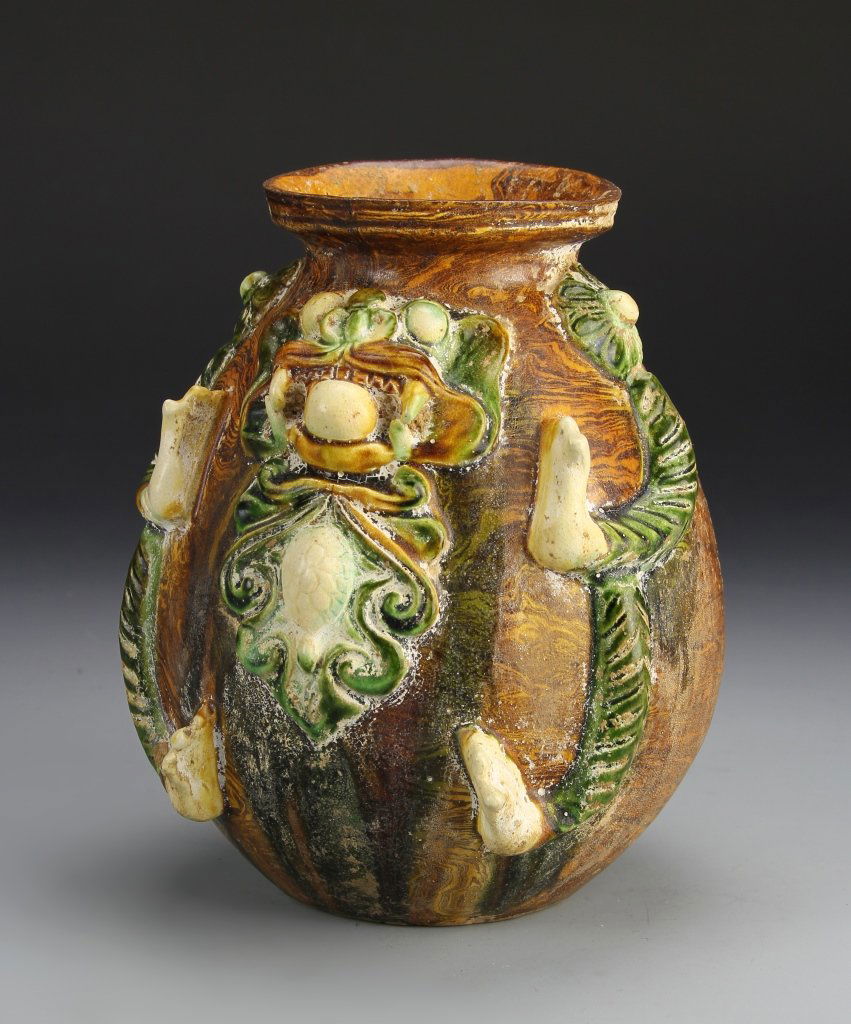 Chinese Tang Style Sancai Jar: China, Tang style Sancai jar, bulbous form with flared rim, raised foliage pattern on body. Height 7 3/4 in.