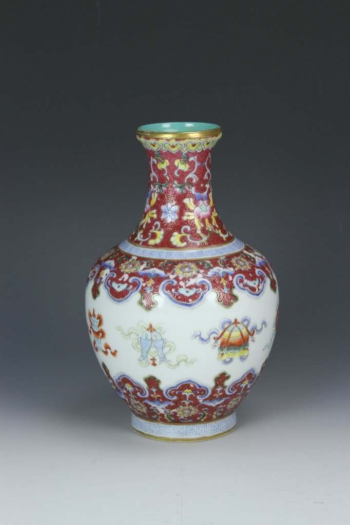 Chinese Famille Rose Vase: China, 18/19th C., Famille Rose vase, with a flared open, a vibrant red ground, auspicious symbols, and a band of key fret decoration, Qianlong mark on base. Height: 7 1/2 in.