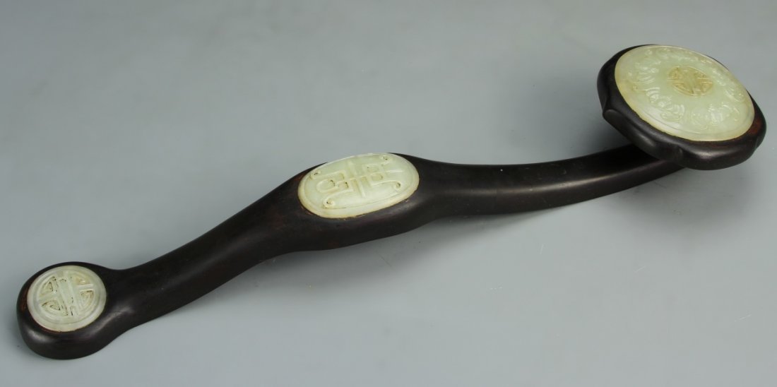 Chinese Carved Jade and Wood Ruyi: China, intricately carved jade and wood Ruyi scepter, with auspicious symbols and bats adorning the jade medallions. Length 18 in.