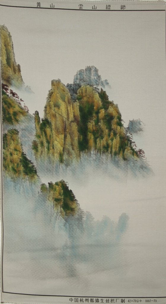 Chinese Silk-Woven Art of The Yellow Mountain: China, silk-woven art of the Yellow Mountain as it appears out of a misty landscape, distant trees can be see on the rocky cliffs. Width 17 in., Height 29 1/2 in.