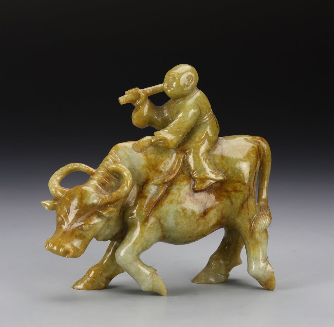 Chinese Jade Boy on Bull: China, jade boy on bull, bull in walking position mid step, boy seated atop looking out of a kaleidoscope, orange hue, with striations in stone. Height 5 in.