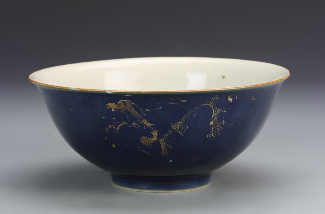 Chinese Blue Bowl: China, ROC Period, blue bowl, with faint dragon decoration in gilt around the outside, and white glazed interior with mark, chips on rim. Height 7 in., Width 3 in.