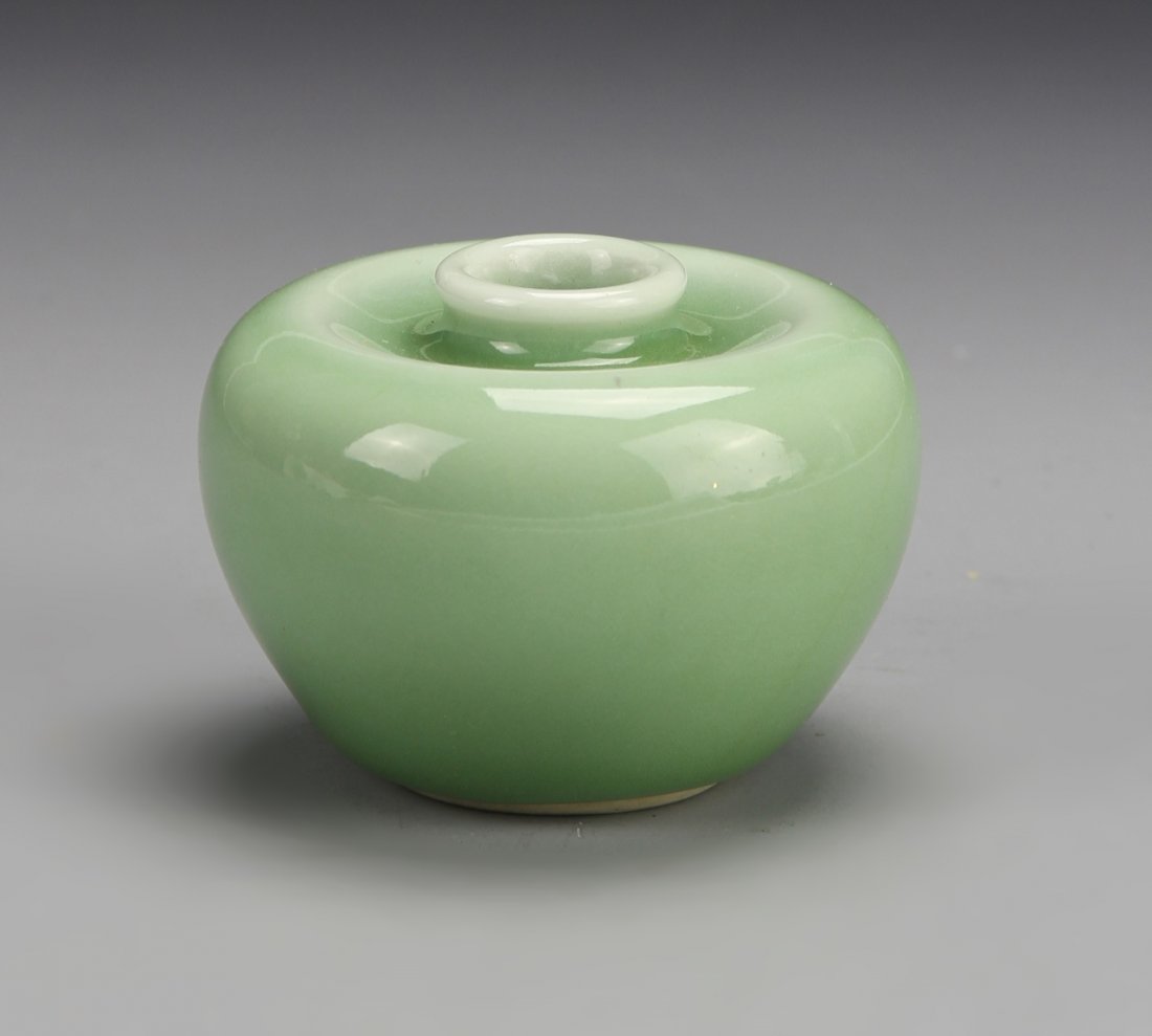Chinese Apple Green Water Cup: China, 19th C., apple green water cup, in the form of an apple, with flat base, concave shoulder with small circular lip, pale green in color, with Guanyin mark. Height 2 in.