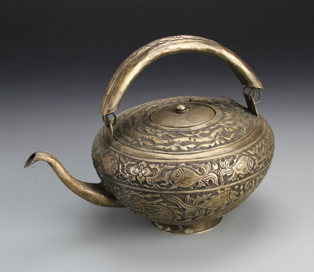 Chinese Antique White Copper Teapot: China, antique white copper teapot, narrow spout and high-handle, intricately carved fish design on body. Dimensions 9 1/2 x 4 in.