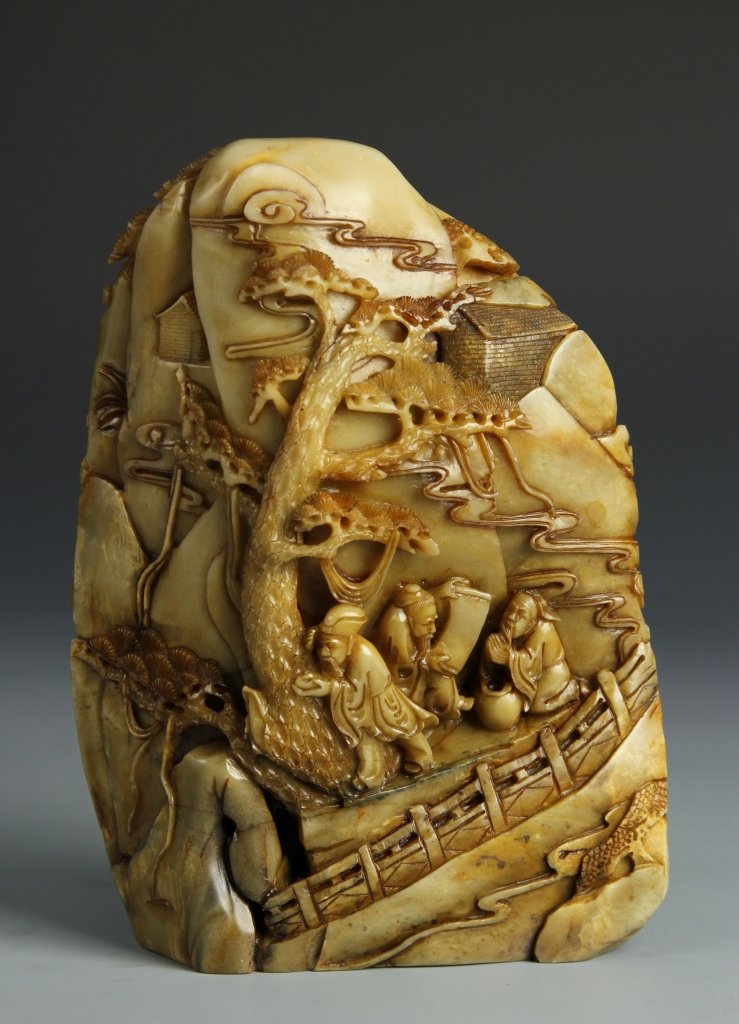 Chinese Carved Soapstone Mountain: China, carved soapstone mountain decorated with scholar figures amidst pine trees and buildings in the distance. Height 8 1/2 in., Width 1/2 in.