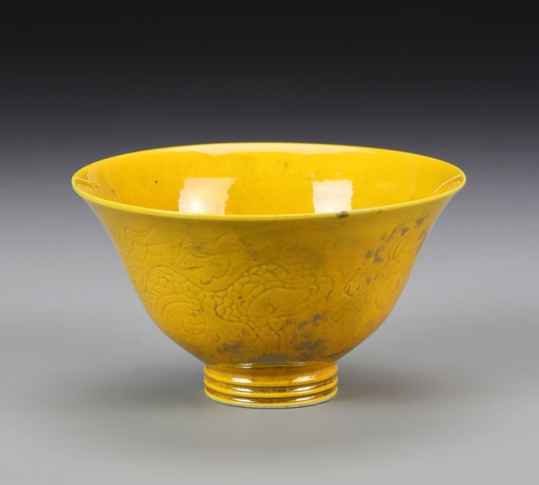 Chinese Yellow Glaze Bowl: China, yellow glaze bowl, with incised dragon motifs, footed base, in a bright yellow color, with high shine surface, with mark. Height 2 in.
