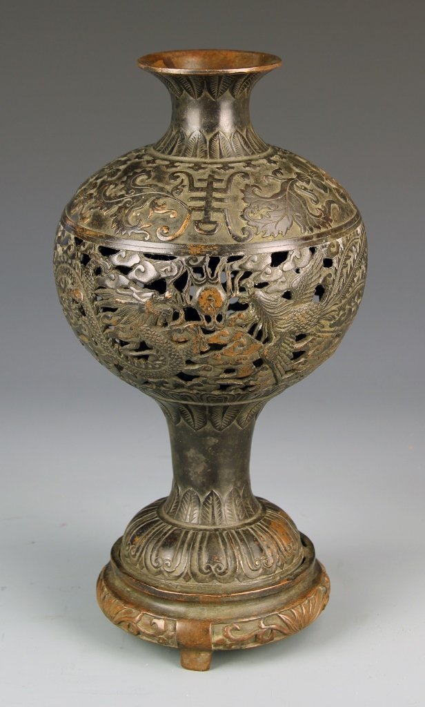 Chinese Bronze Vase: China, 19th C., bronze vase with a raised body and long narrow foot and a flared neck and lip, the body decorated with a incised dragon and phoenix, with mark on base. Height 11 1/2 in.