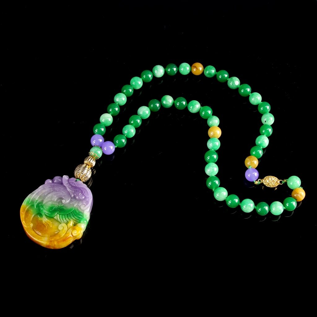 Chinese Jade Pendant and Necklace: China, jade pendant and necklace, pendant in the firm of a dragon, with yellow, green and purple striations, and spherical beads in similar hues. Length 13 1/2 in.