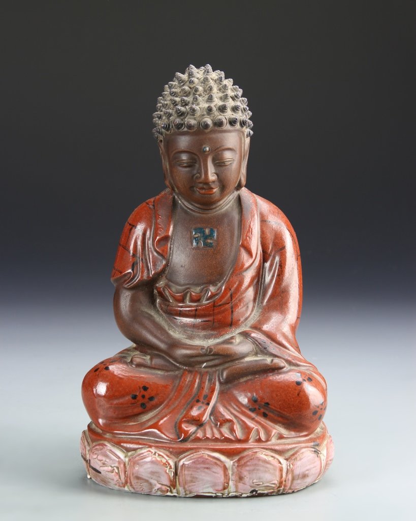 Chinese Glazed Buddha: China, 19th century, glazed Yi Xing Buddha, in seated position, with detailed robes, high shine surface, in a bright red hue. Height 9 in.