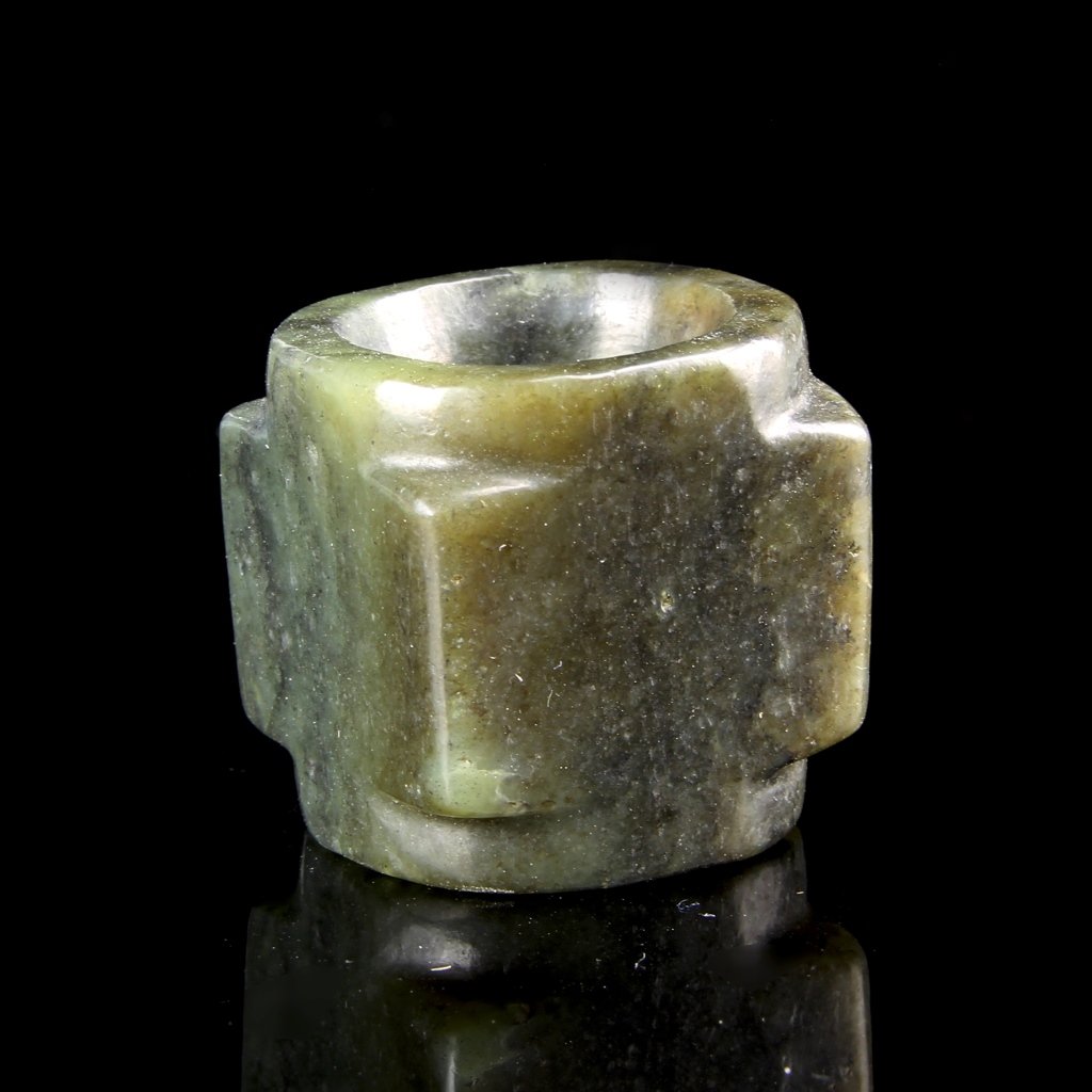 Chinese Jade Thumb Ring: China, antique jade thumb ring, in the form of a cong with squared corners and rounded rims, in a dark green color with light variations. Height 1 in., Diameter 1 1/4 in.
