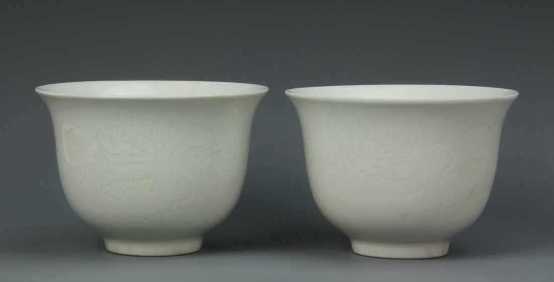 Pair of Chinese White Glazed Cups: China, Ming Period, a pair of white glazed cups, raised base and flared rim, with incised dragon on exterior, and Yongle mark. Height 2 1/2 in., Width 3 1/2 in.
