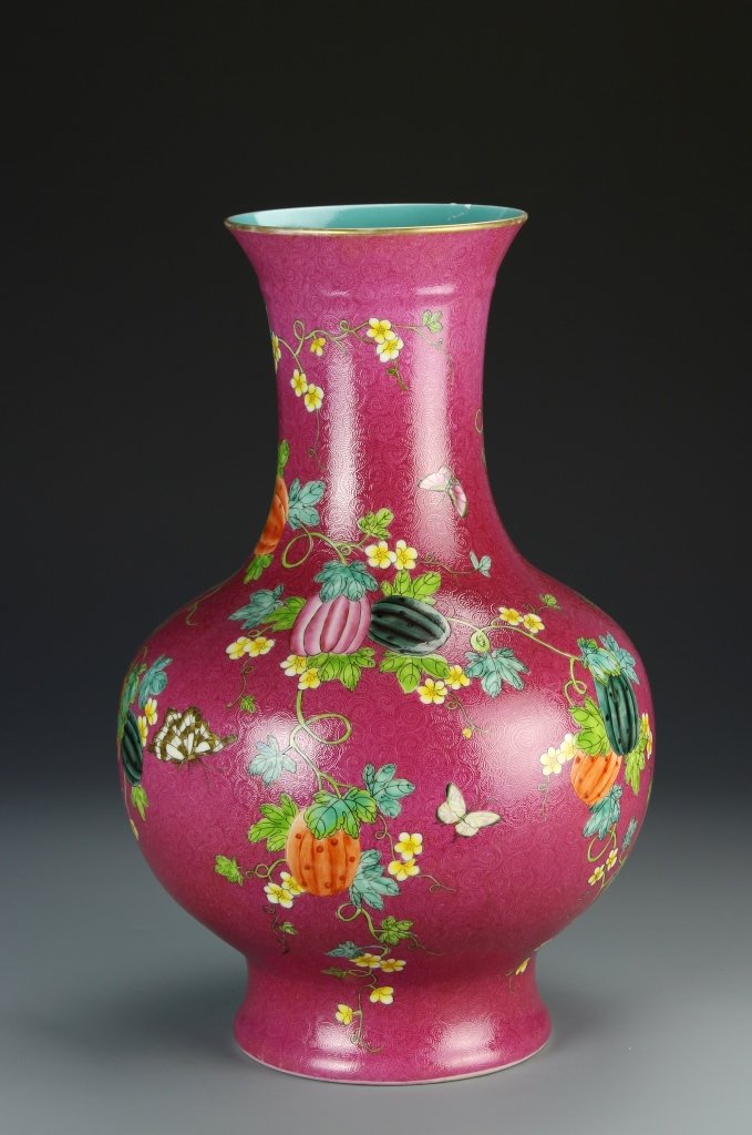 Chinese Famille Rose Vase: China, Famille Rose vase, flared rim, long neck, bulbous body on high footed base, deep pink ground with berries on vines twisting around the piece, Qianlong mark on turquoise base. Height 16 in., Wid