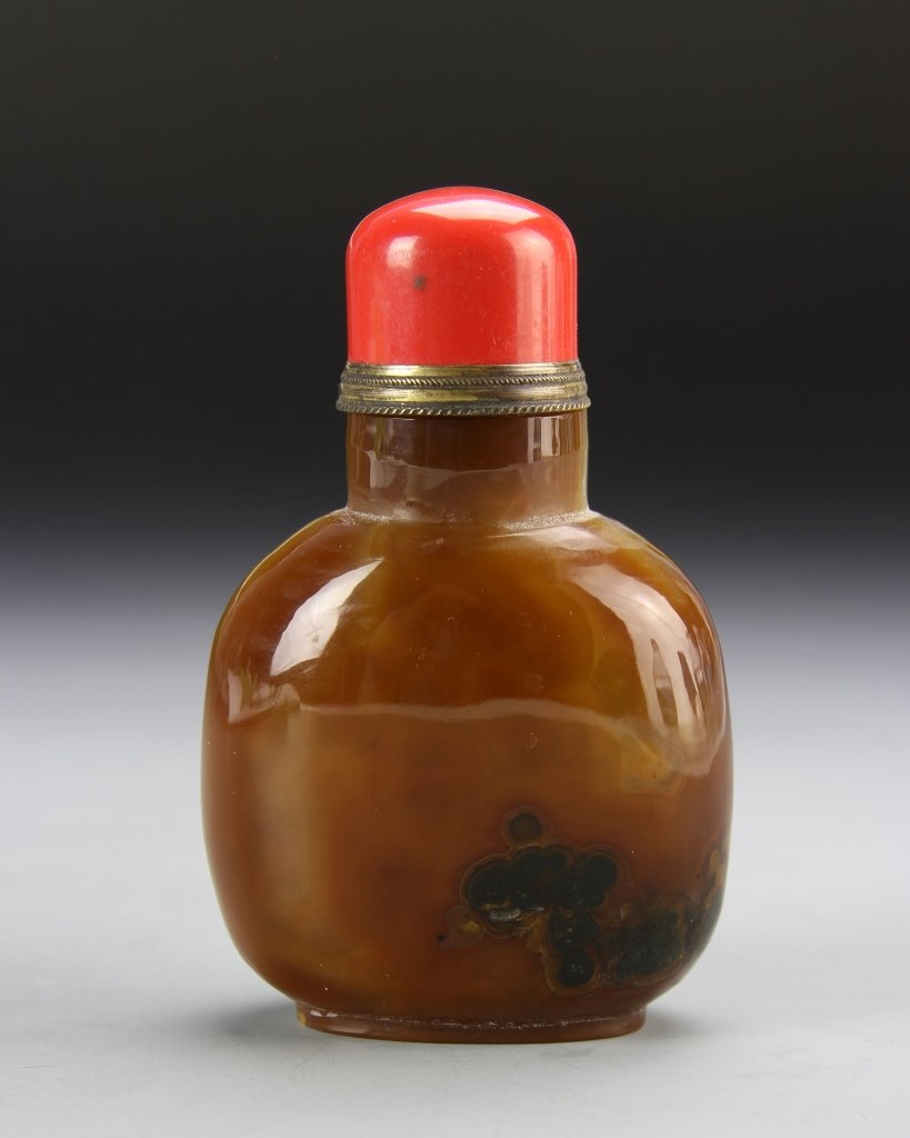 Chinese Agate Snuff Bottle: China, ROC Period, agate snuff bottle, flattened circular form, in a brown hue, with striations in the stone, and a high shine surface, with a red stopper. Height 3 3/8 in.
