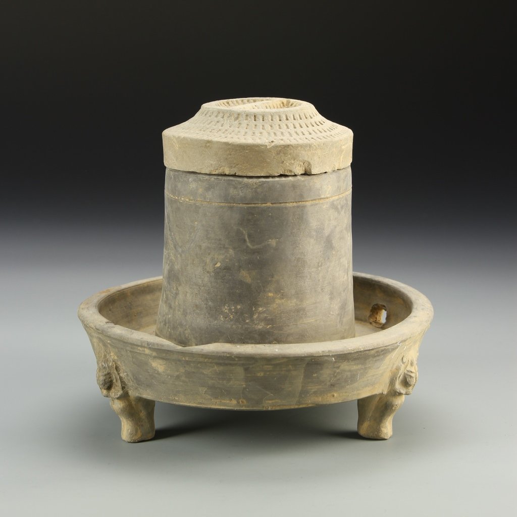 Chinese Pottery Grinder: China, Han Dynasty, pottery grinder, with tripod footed base, in a brown hue, with textured surface, and matching cover. Height 7 in.