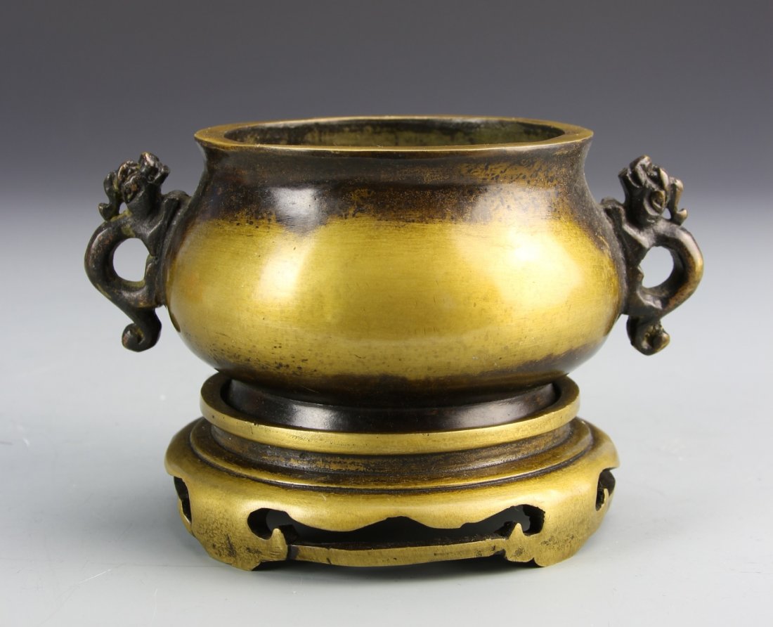 Chinese Bronze Censer: China, 19th C., bronze censer with base, a dark patina lines the rims and handles, and the handles are in the shape of dragons, there is a mark on base. Height 3 3/4 in.