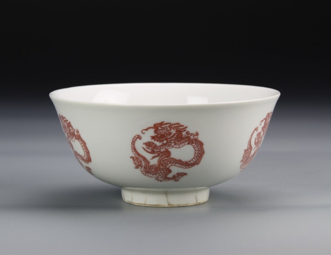 Chinese Copper Red Dragon Bowl: China, 19th C., copper red dragon bowl, raised base, white ground with five-clawed dragons, high shine surface, with Kangxi mark on base. Width 6 1/4 in., Height 2 1/6 in.