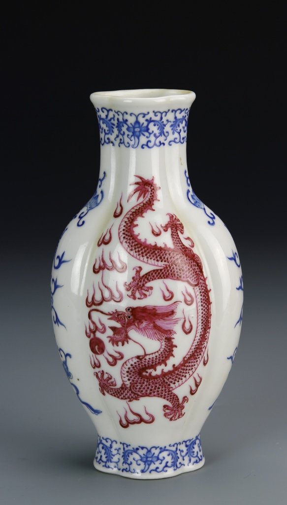 Chinese Blue and Red Vase: China, blue and red vase, in an upright form with an undulating surface, decorated with a serpentine dragon in red, Qianlong mark. Height 7 in., Width 3 3/4 in. Provenance: From the private collection