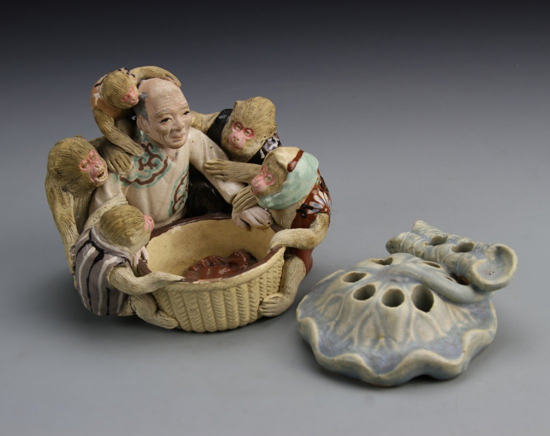 Two Japanese Porcelain Items: Japan, two porcelain items, one statue of a figure and five monkeys around a basket, and a smaller blue glazed item in the form of a flower. Height 3 1/2 in.