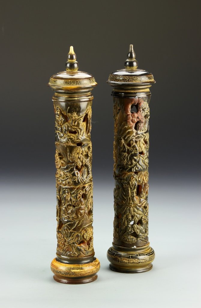 Pair of Chinese Horn-Carved Incense Holders: China, a pair of horn-carved incense holders, tall slender forms with deeply carved landscape scene with figures and birds, with covers. Height 1 in.