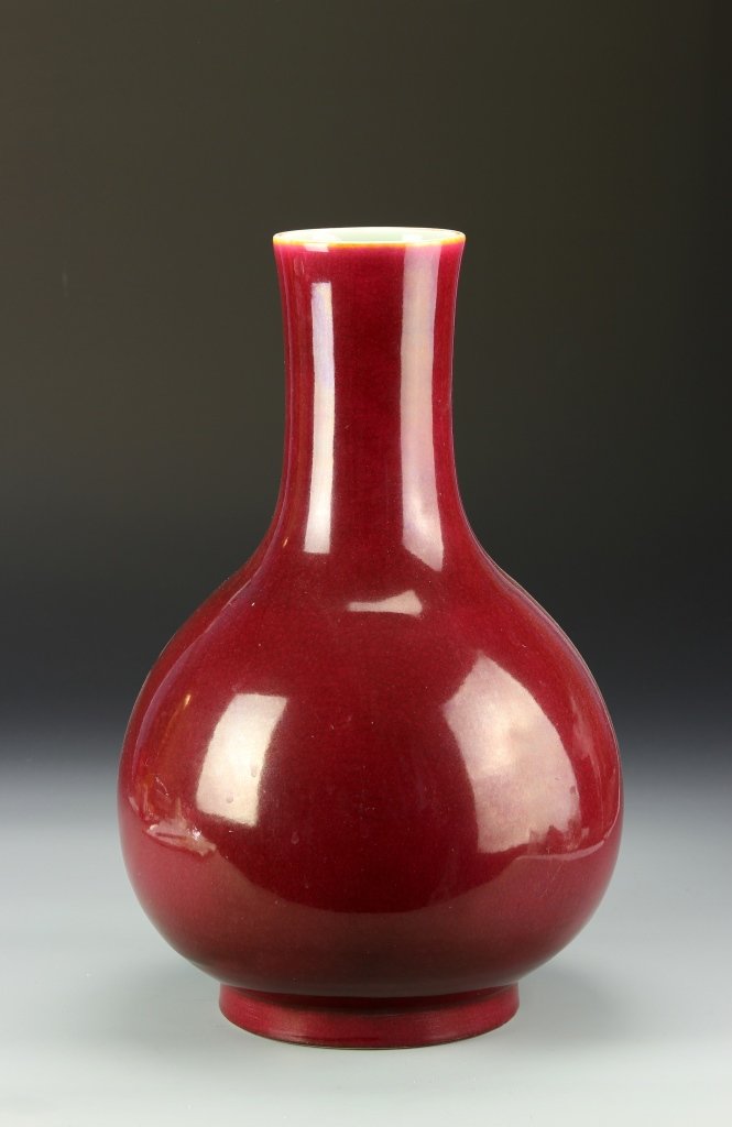 Chinese Ox-Blood Glazed Vase: China, ox-blood glazed vase, with bulbous body, elongated neck, platform base, in a bright red hue, with high shine surface, Qianlong mark. Height 14 1/2 in.