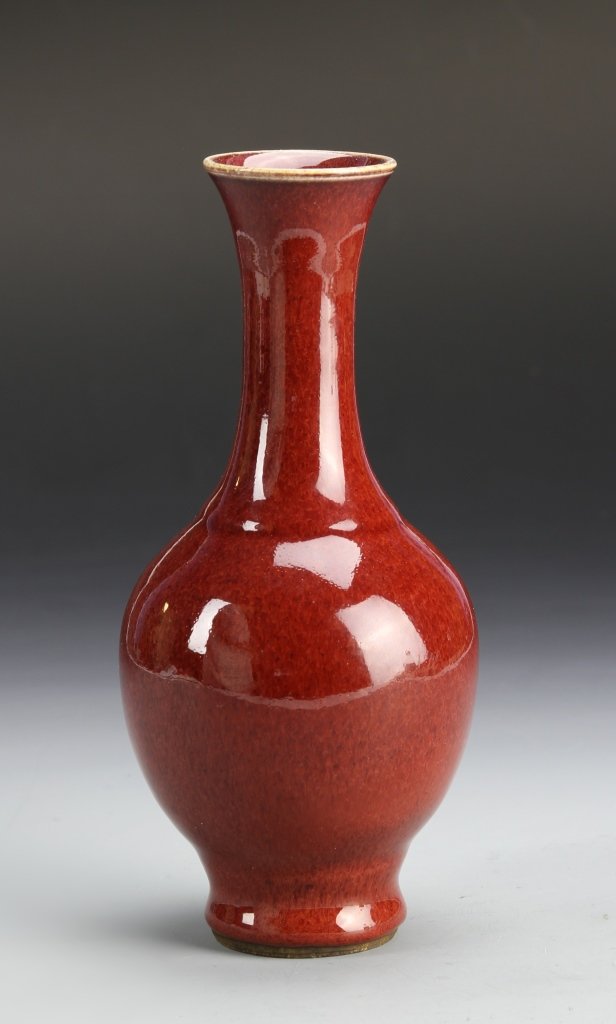 Chinese Oxblood Glazed Vase: China, 19th C., oxblood glazed vase, in bulbous form, with elongated, flared neck, in a bright red color, and high shine surface. Height 7 in.