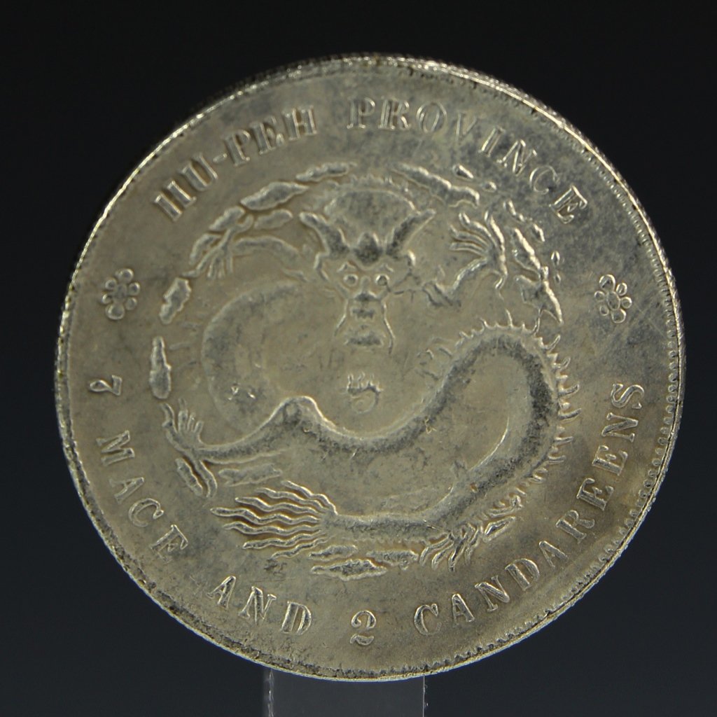 One Chinese Coin: China, Qing dynasty, Guangxu period, reads "7 Mace and 2 Candareens" made in Taiwan, with a central serpentine dragon. Diameter 1 1/2 in.