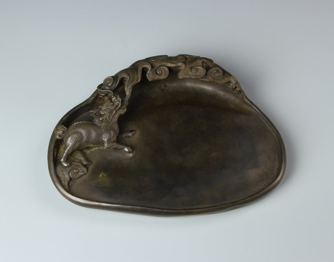Chinese Inkstone Pad: China, inkstone pad, a smooth, flat surface with one edge curling upward and folding inward into flame motifs, with a mythical creature breathing the flames, mark on base. Length 9 in., Width 6 3/4 in