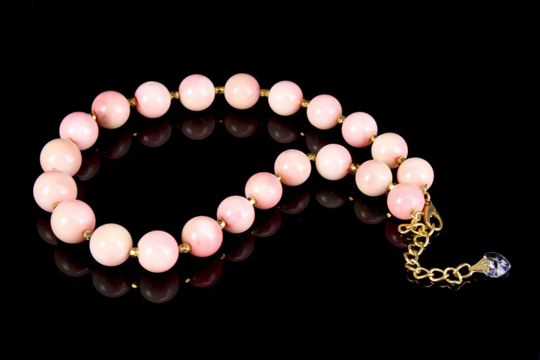Chinese Coral Necklace: China, coral necklace, 22 beads, rounded in form, light in color, high shine surface, small narrow gold colored spacers. Length 17 in.