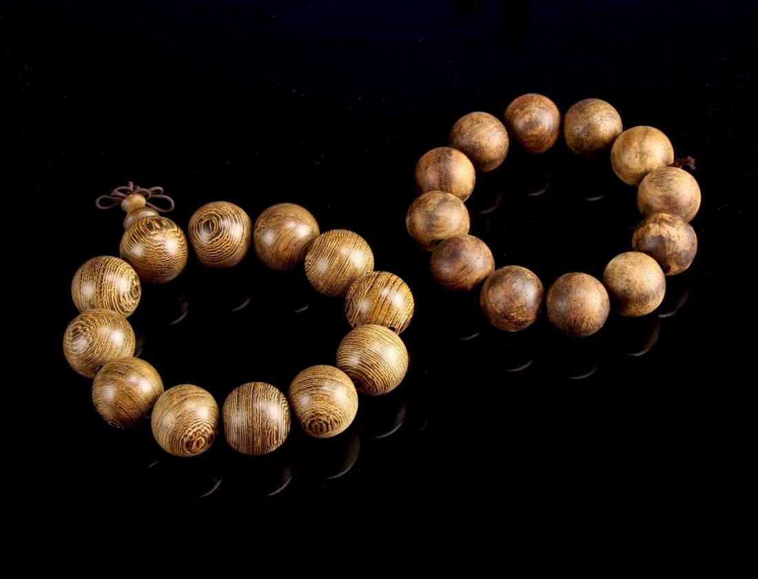 Two Chinese Hardwood Bracelets: China, two hardwood bracelets, each with twelve spherical beads, in a dark shade with natural wood grain visible.