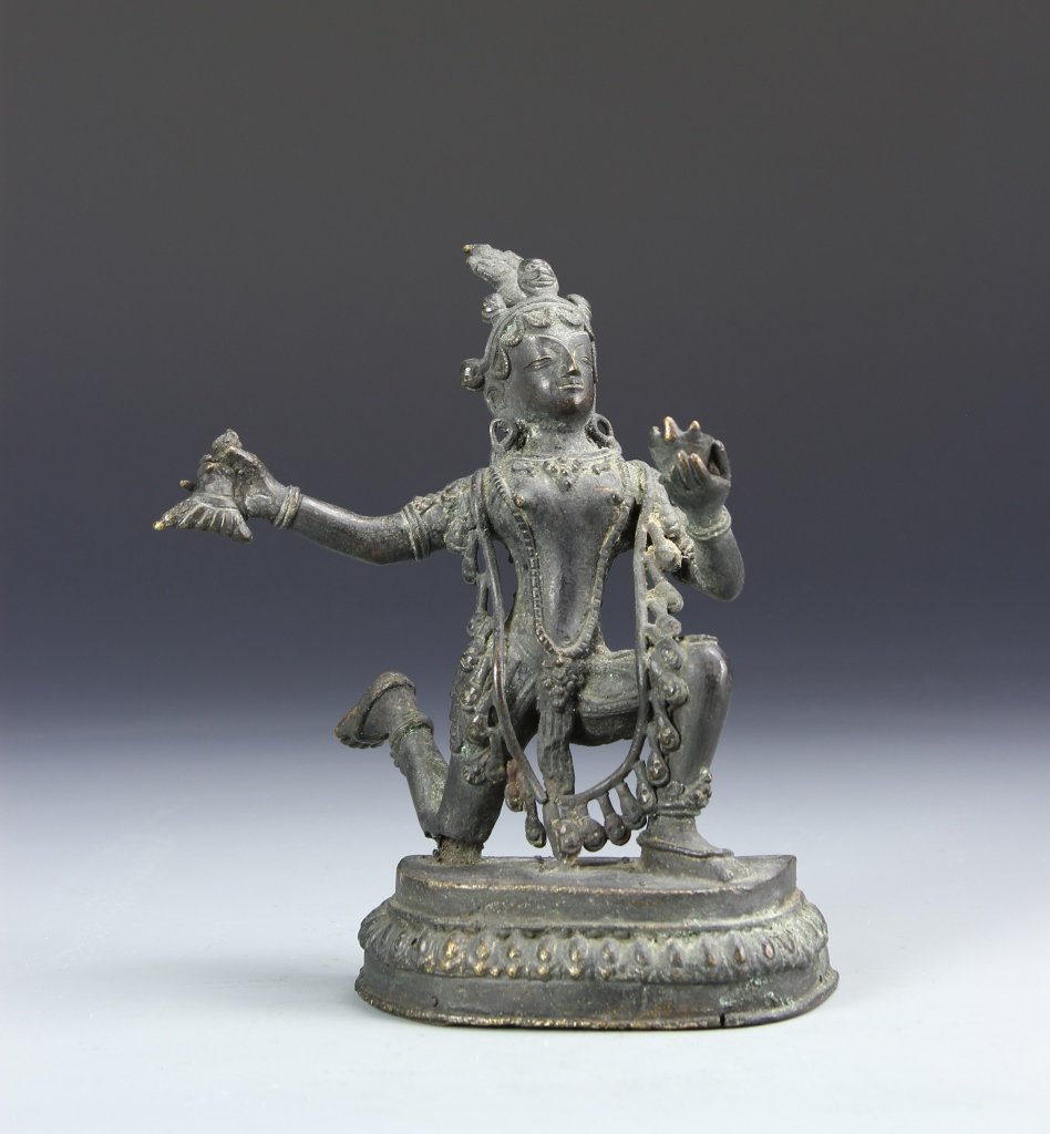 Asian Bronze Figure: Asia, bronze figure, depicted in a kneeling pose with one arm extended, the other clasping a fish, adorned in decorative body jewelry and headdress, on a raised lotus base, Height 7 in.