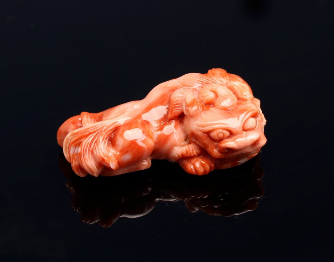 Chinese Coral Pendant: Chinese, coral pendant, in the form of a carved mythical creature, in a bright orange-red hue, reclining position, and with striations in the coral. Length 1 3/4 in., Weight 30 g.