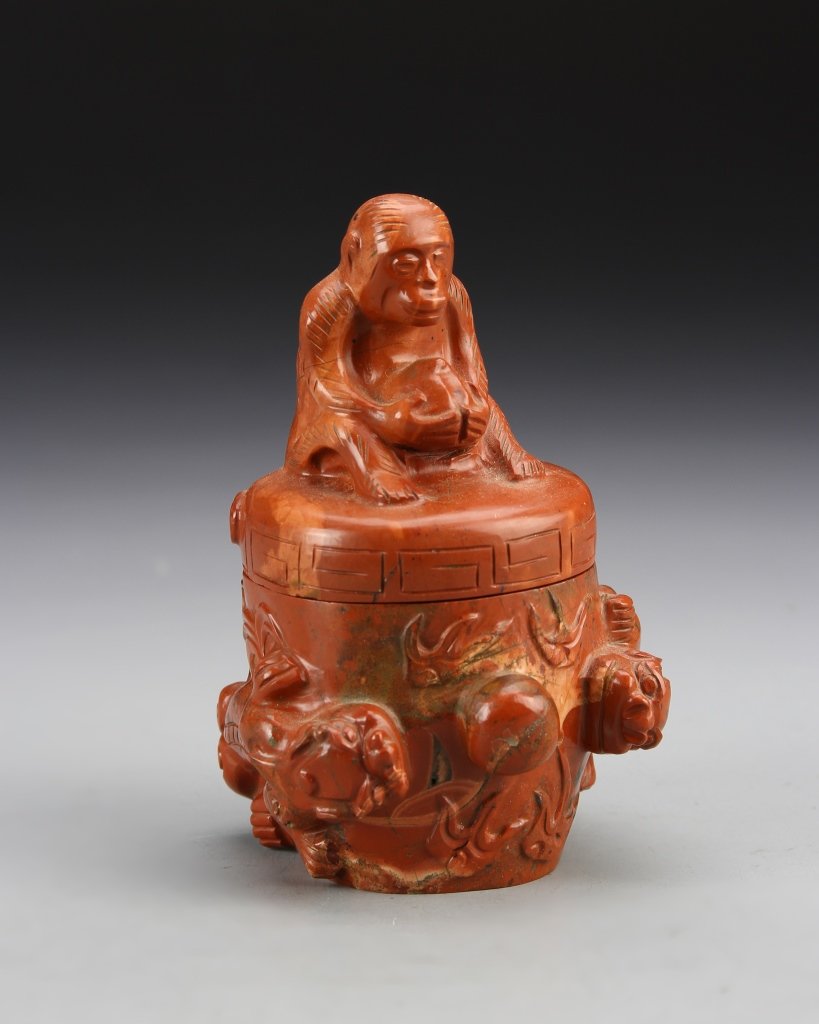 Chinese Agate Censer: China, agate censer, cylindrical in form, with flat cover, monkey figure in seated position on cover, holding a bundle, raised relief on body. Height 4 1/8 in.