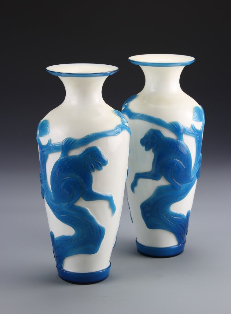 Pair of Chinese Peking Glass Vases: China, pair of Peking glass vases, narrow base flaring to a wide shoulder, narrow neck and flared rim, white ground with blue painted monkeys seated in trees. Height 10 1/8 in.