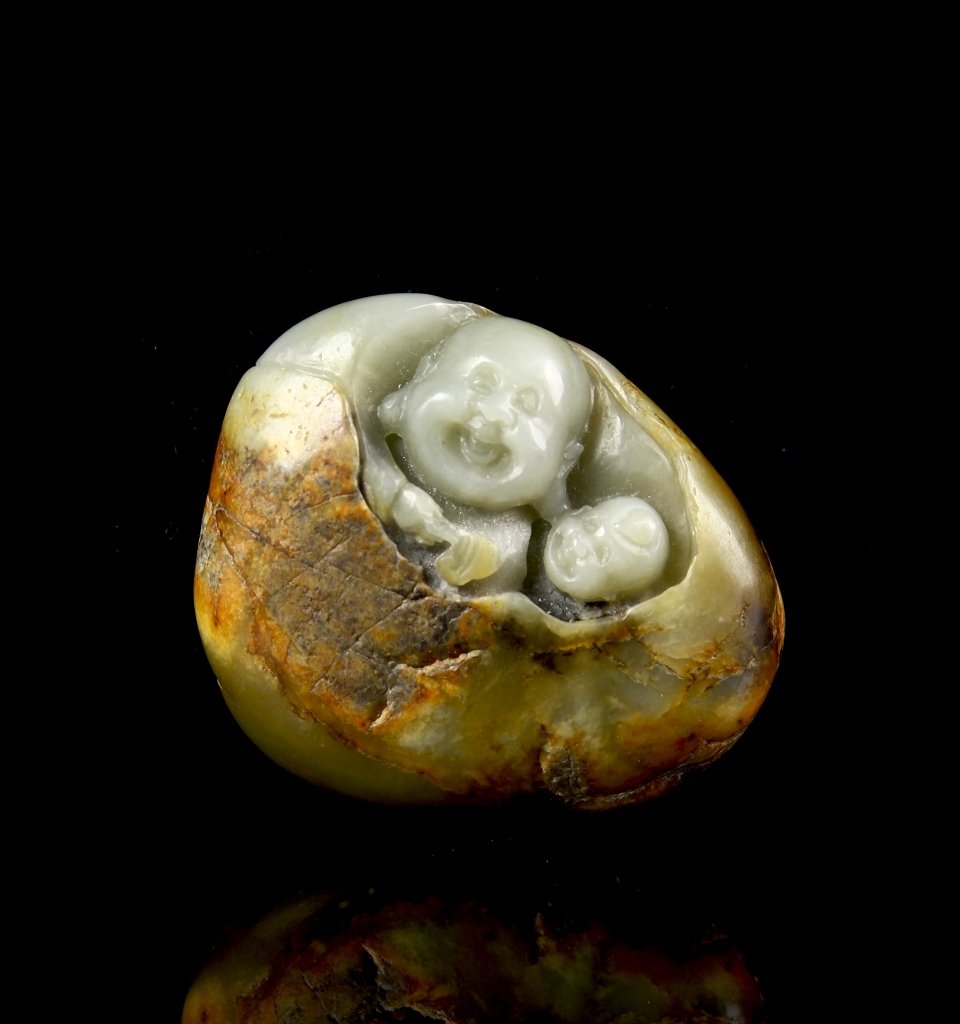 Chinese Jade Pebble: China, Jade pebble, in a round form, in a mottled, organic hue, carved with two smoothly rendered, smiling Buddha faces the center. Width 2 1/8 in., Height 1 7/8 in.