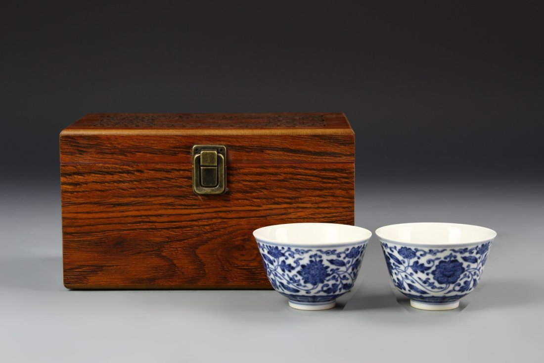 Pair of Chinese Blue and White Wine Cups: China, 19th.C., a pair of blue and white wine cups, high steep sides severely taper to flat base, painted floral design on exterior with Yongzheng mark on base and decorative wooden box. Height 2 in.,