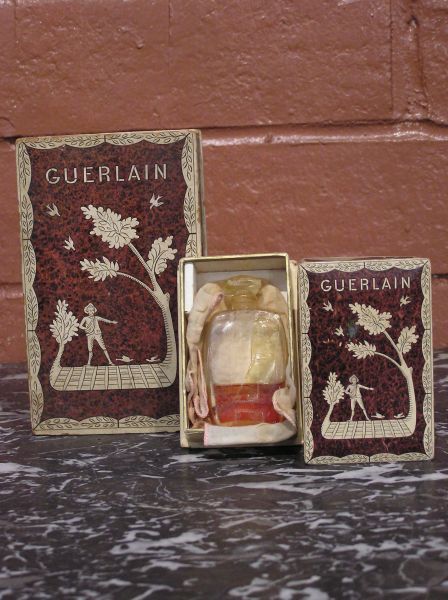 Pair of Guerlain Decorated Boxes: Pair of decorated Guerlain boxes. The large box is empty and the small perfume box has a glass perfume bottle with some fragrance still in it. Please read our terms before bidding.