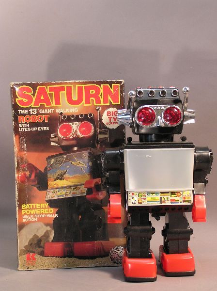 "Saturn" Battery Operated Robot: "Saturn" 13 inch battery operated robot. Eyes light up, walking action and has a big TV screen in the center. Model No. 1981. Made in Hong Kong. Uses two D-cell batteries. Box has scuffs and is bent.